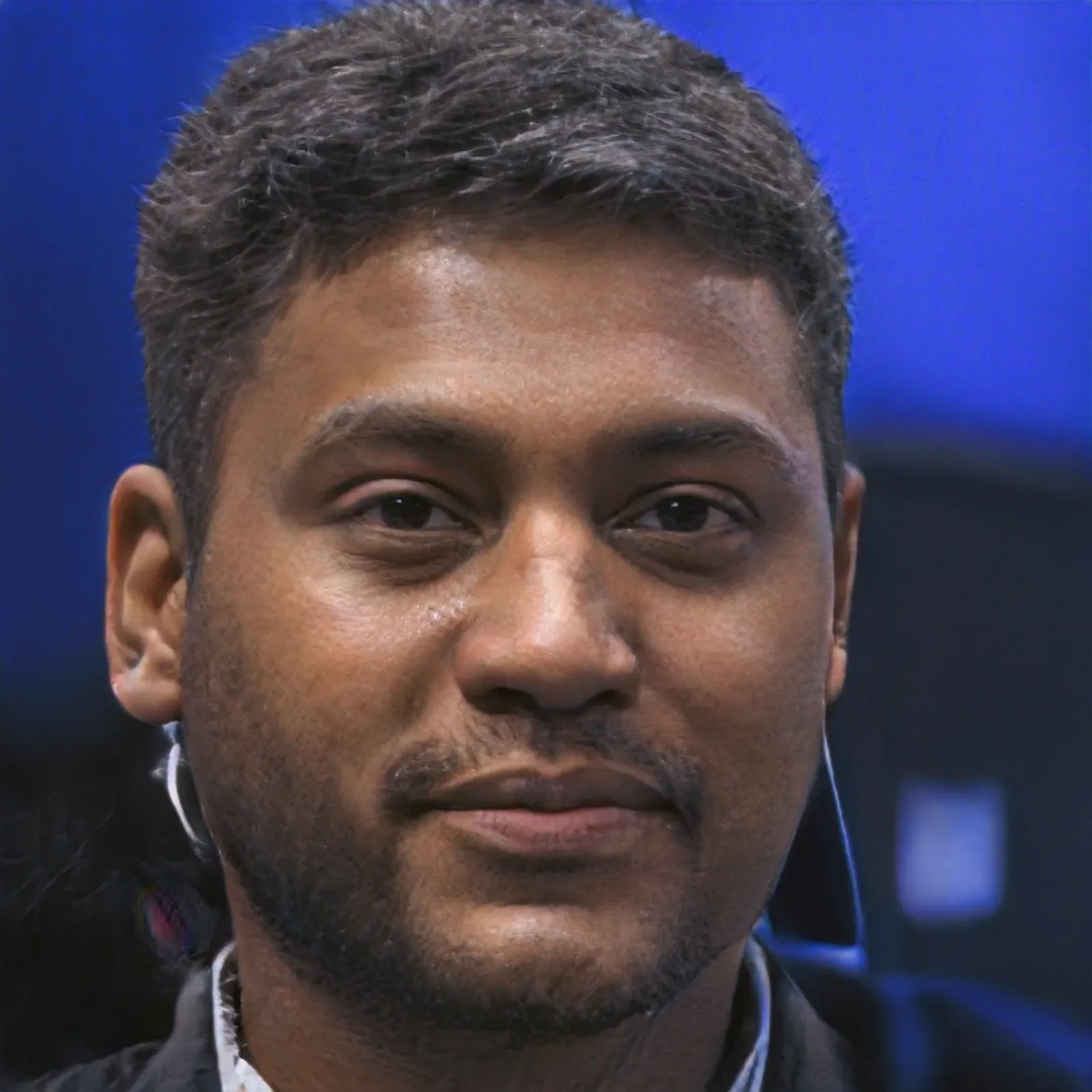 A photorealistic portrait of a man who does not exist, generated by StyleGAN, a distorted white loop dangling from his ear.